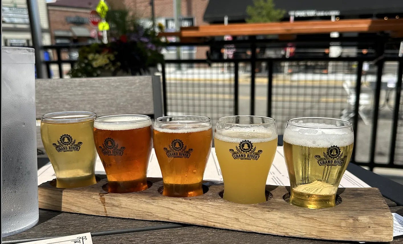 beer flight at grand river brewery overlooking main street in downtown brighton on a sunny summer day